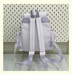 Detail view of purple polka dot backpack with adjustable straps and drawstring side pockets