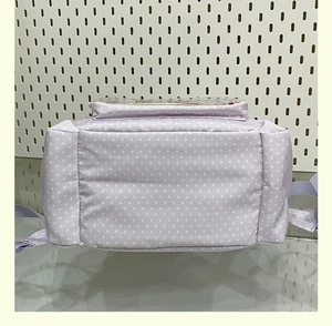 Detailed back and base view of lavender polka dot school backpack with durable straps