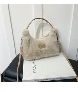 Detail of plush faux fur shoulder bag with brown leather strap and metal buckle accent