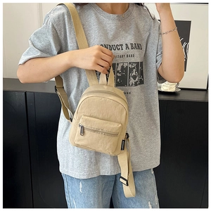 Mini khaki nylon backpack with adjustable wide strap and front zipper pocket detail