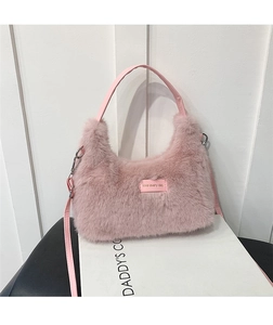 Detailed shot of pink plush faux fur bag featuring a love every day decorative patch