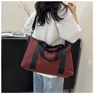 Model view of burgundy large capacity travel bag with nylon texture and black straps