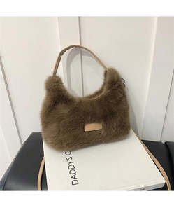 Detail of soft brown faux fur shoulder bag featuring leather tag with love every day text