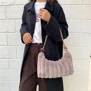 Chic faux fur underarm bag with a ribbed texture and plush finish worn by a model
