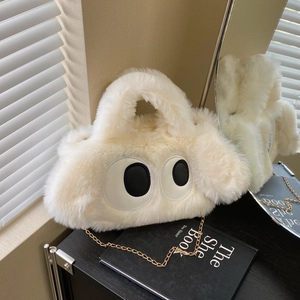 Gros plan sur un sac à main blanc en peluche avec yeux de dessin animé et chaîne dorée