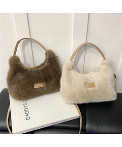 Detail of plush faux fur shoulder bags in coffee and cream with slim leather handles