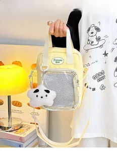 Detalle de bolso Ita de lona amarilla con bolsillo de malla y colgante de estrella