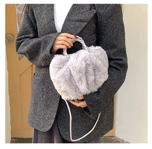 Gray plush cloud bag with twisted handle shown on model in a tweed blazer