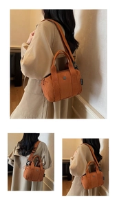 Detail view of the orange nylon shoulder bag featuring wide fabric straps and metal logo