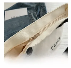 Gros plan d'une fermeture éclair en métal et de la doublure d'un sac cabas en toile