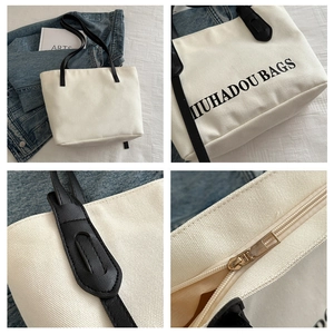 Détails du sac cabas en toile avec bandoulières en cuir noir et fermeture éclair