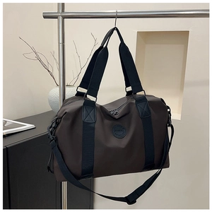 Detail view of large dark brown travel bag with durable nylon fabric and shoulder strap