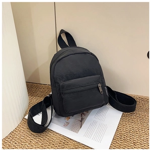 Close-up of durable black nylon mini backpack with zipper pocket and woven side label