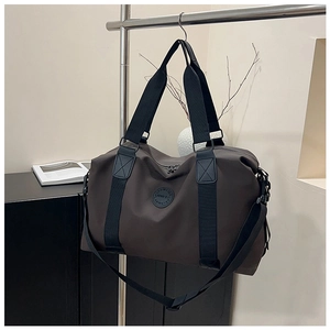 Close-up of large travel bag with durable black handles and adjustable shoulder strap