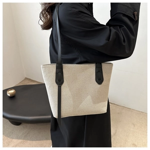 Détail du sac cabas minimaliste en toile avec lanières en cuir noir et gros plan