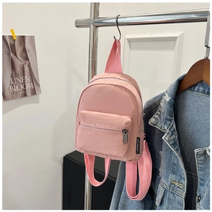 Detail of pink nylon mini backpack with adjustable woven straps and front zipper pocket