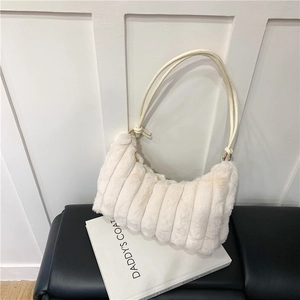 Detailed texture of creamy faux fur shoulder bag with elegant gold metal ring accents