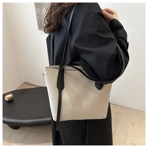 Détail du sac cabas minimaliste en toile avec anses en cuir noir et nœud décoratif