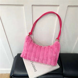 Detail of bright pink faux fur shoulder bag featuring tied leather straps and gold metal rings