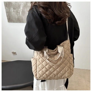 Detail view of the quilted puffer tote bag in beige nylon fabric with soft texture