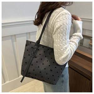 Détail du sac cabas gris avec pois noirs et broderies délicates en forme de nœuds