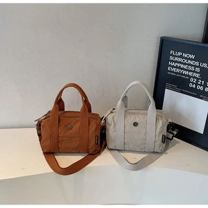 Close-up of nylon Boston bags with dual handles and detachable wide shoulder straps