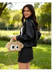 Détail du sac en peluche avec des yeux de dessin animé et une chaîne dorée