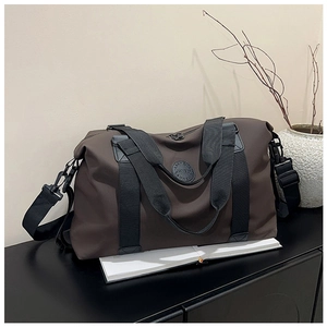 Detailed macro view of deep brown large travel bag with leather logo and metal hooks