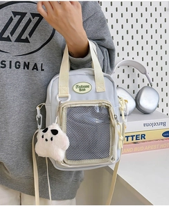 Detalle del bolso de lona azul claro con bolsillo transparente y colgante de nube suave