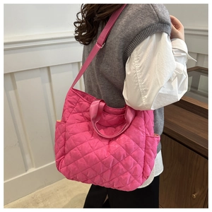 Close-up of hot pink quilted tote bag with adjustable strap and diamond stitching