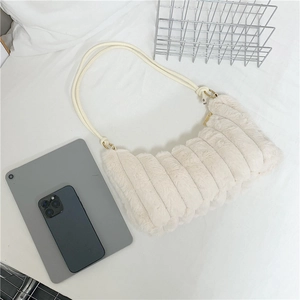 Detail of soft cream plush shoulder bag featuring vertical quilted faux fur texture