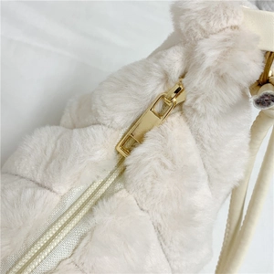 Detailed close-up of a premium white plush faux fur bag with a gold metal zipper
