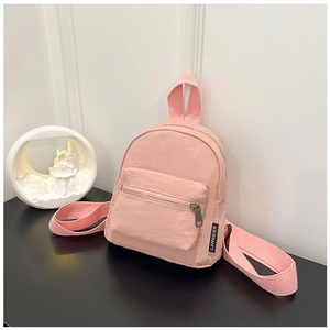 Detailed view of pale pink nylon mini backpack with metal zipper and logo tag