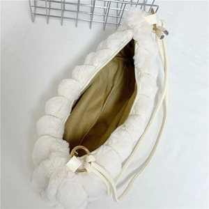 Close-up of white faux fur shoulder bag featuring bubble texture and khaki lining details