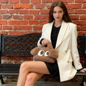 Sac à main en fausse fourrure marron avec yeux de dessin animé et chaîne dorée sur modèle