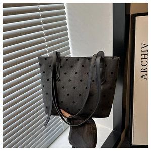 Gros plan du sac fourre-tout en toile grise à pois noirs et petits détails de ruban