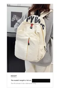 Detail of off-white nylon backpack with Happy Days print and red zipper pull on model