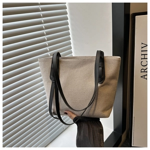 Détail de la texture tissée et des anses noires sur un sac cabas en toile élégant