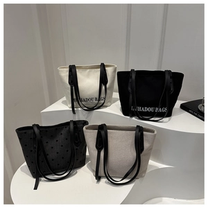 Vue détaillée de quatre sacs cabas minimalistes en toile sur un socle blanc