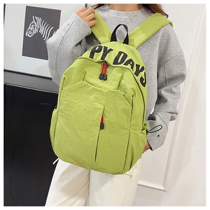 Detail view of the green nylon backpack featuring the Happy Days print and red zipper cord