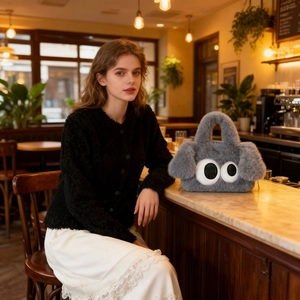 Détail du sac à main en fausse fourrure grise avec yeux mignons et chaîne en métal