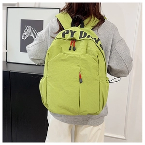 Close-up of light green nylon backpack featuring HAPPY DAYS print and red zipper pulls