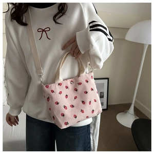 Close-up of pink corduroy tote bag with strawberry print and fabric shoulder strap