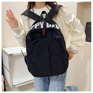 Close-up of the HAPPY DAY print and side drawstring detail on a black backpack