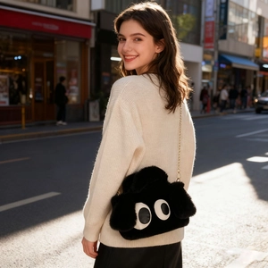 Détail du sac bandoulière en peluche noire avec yeux mignons et chaîne dorée