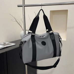 Large capacity gray travel duffel bag with black straps hanging on a metal rack