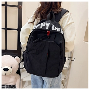 Close-up of black nylon backpack featuring white Happy Day print and red zipper detail