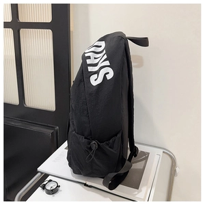 Detail view of large capacity black nylon backpack side pocket with DAYS letter print