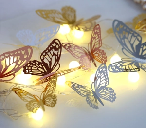 Close-up of golden hollow butterfly LED string lights with warm yellow bulbs for decor