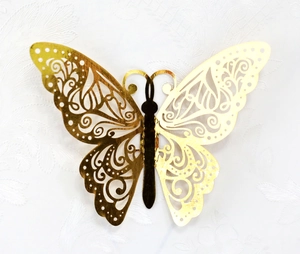 Detailed macro view of 3D gold hollow butterfly wall sticker with laser-cut lace pattern